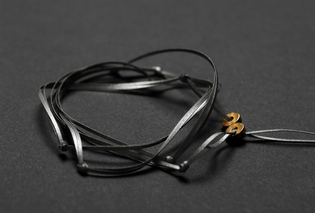Fußring <em>Knot</em>. Laminiertes, reflektierendes Material, geknüpft, vergoldete Magneten, D 0,1 cm. Foto Hanna Pribitzer